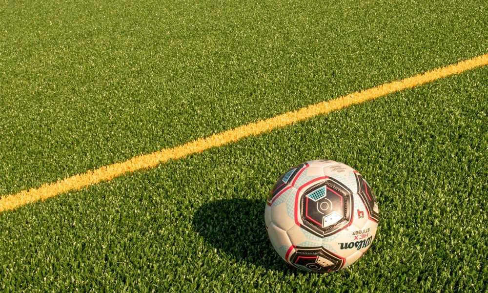 Why is artificial turf the first choice for professional football fields?