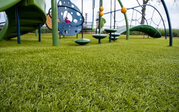 Why is artificial turf suitable for playgrounds?